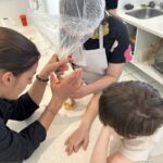2 jeunes et Elona remplissent un fond de tarte