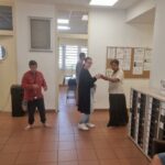 Trois personnes dansent dans le grand hall