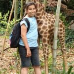 Une jeune fille près d'une fausse girafe