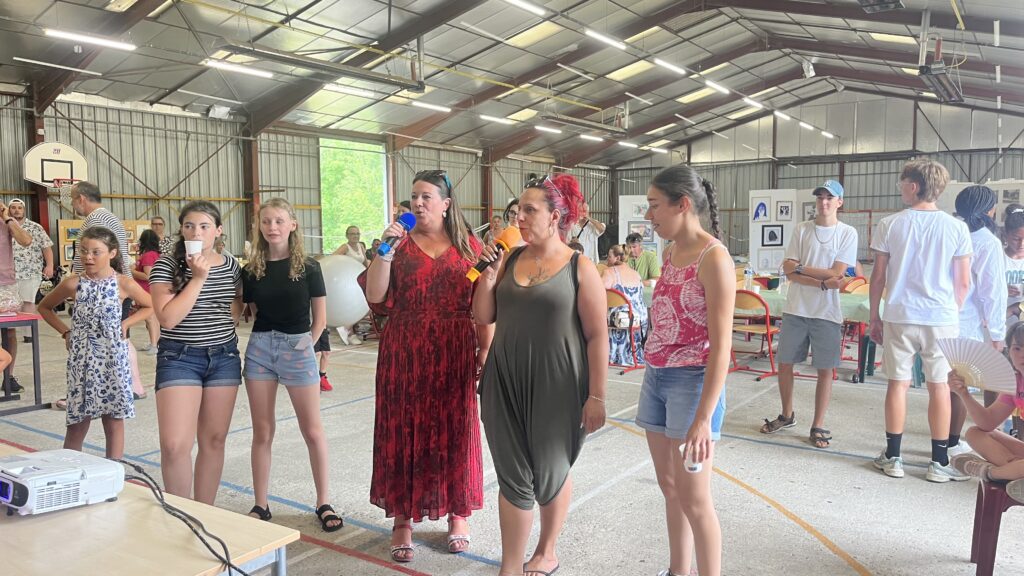 Six personnes, micros à la main pendant le karaoké
