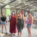 Six personnes, micros à la main pendant le karaoké