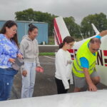 Le pilote, deux jeunes et leur éducatrice prêts à monter dans l'avion
