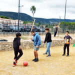 4 jeunes jouent au football dans la cour