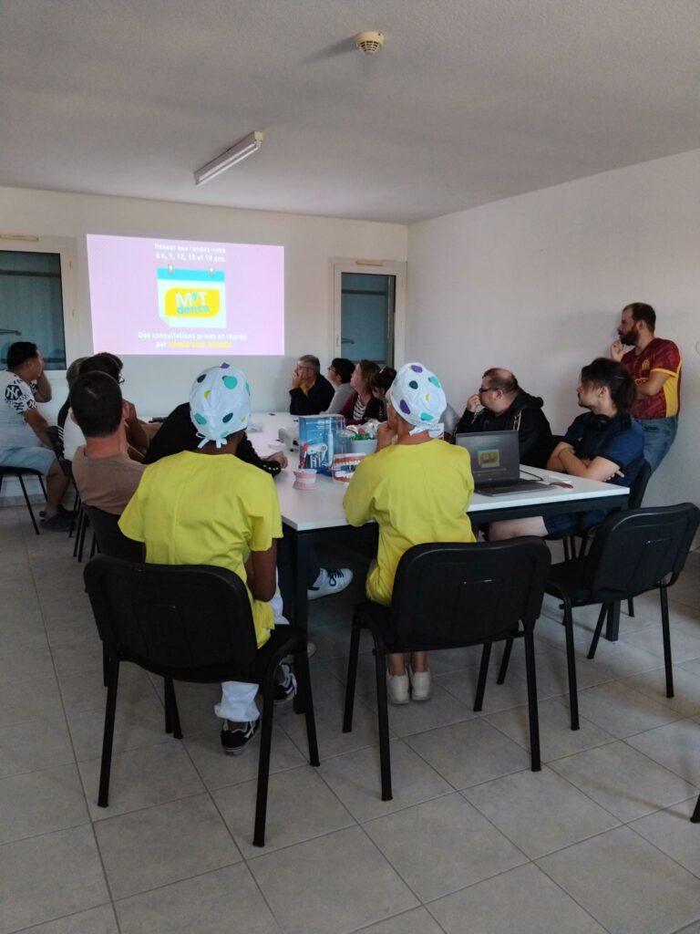 Autour de la table, formatrices, résidents et professionnels visionnent un diaporama