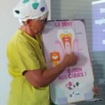 En gros plan, la formatrice montre le schéma d'une dent