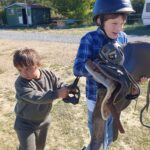Deux jeunes tiennent une selle