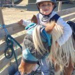 Un jeune accompagné enlace un poney