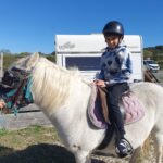 Un jeune accompagné sur un double poney