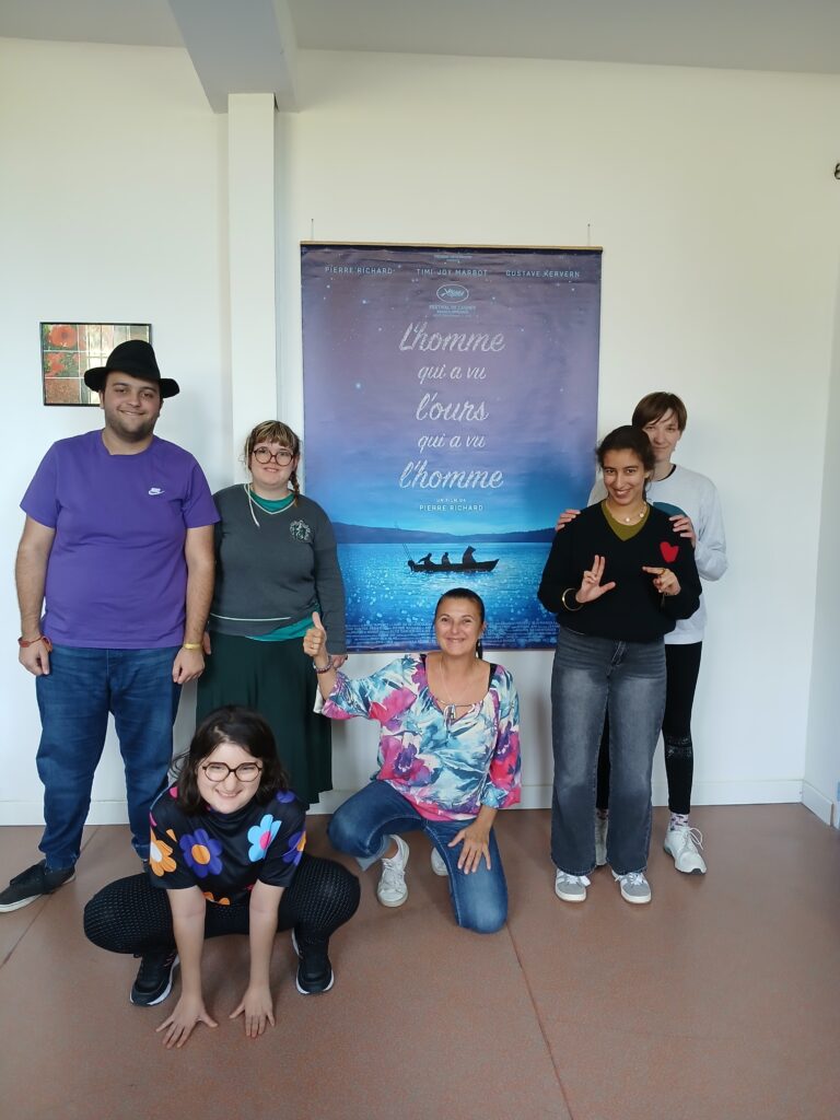 Les jeunes et leur professeur devant l'affiche du film "L’homme qui a vu l’ours qui a vu l’homme",
