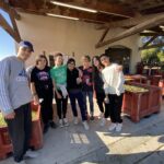 7 jeunes posent devant des cagettes pleine d'olives