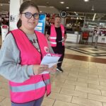 Une jeune fille distribue la liste des produits de première nécessité