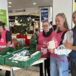 Dans le magasin, les jeunes distribuent les listes de produits prioritaires pour la collecte et réceptionnent les produits collectés dans des bacs