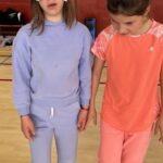 Sur le parquet du gymnase, deux jeunes se tiennent par la main. L'un d'entre eux a les yeux bandés