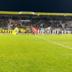 Au milieu du terrain, la ligne constituée par les joueurs et les jeunes