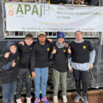 Sur le bord du terrain, les jeunes de l'IME de Pépieux posent devant la banderole de l'APAJH Aude