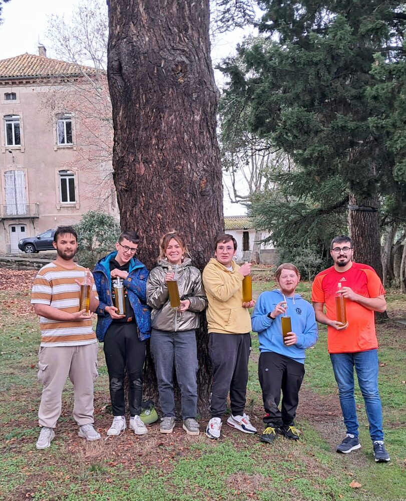 Photo de groupe avec les bouteilles d'huile d'olives dans les jardins de l'IME