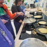 Deux personnes devant les fourneaux