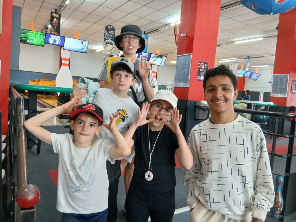 Photo de groupe des jeunes devant la piste de bowling