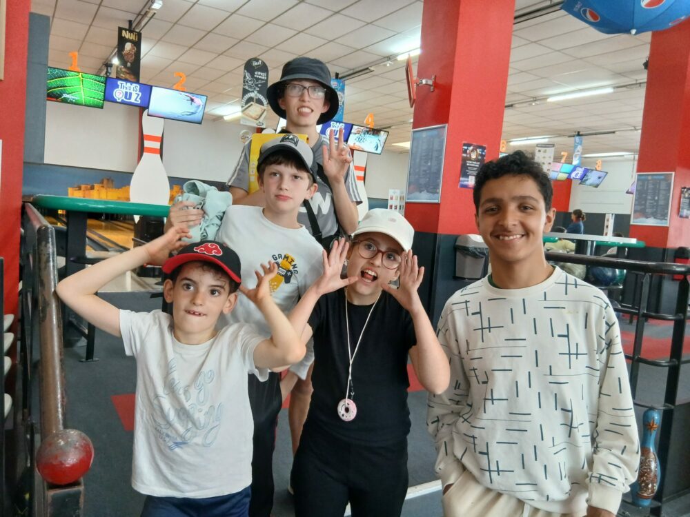 Photo de groupe des jeunes devant la piste de bowling