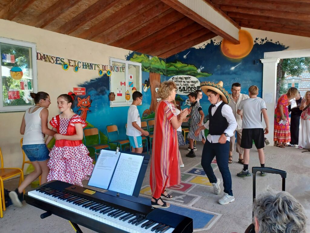 Jeunes et professionnels effectuent une danse sous le préau